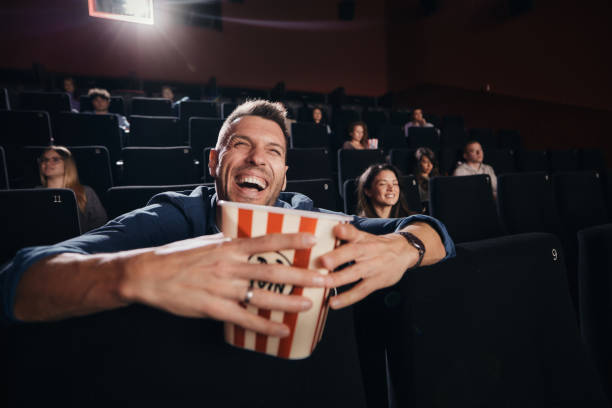istock Cheerful man having fun while watching a movie in cinema. 1936994698