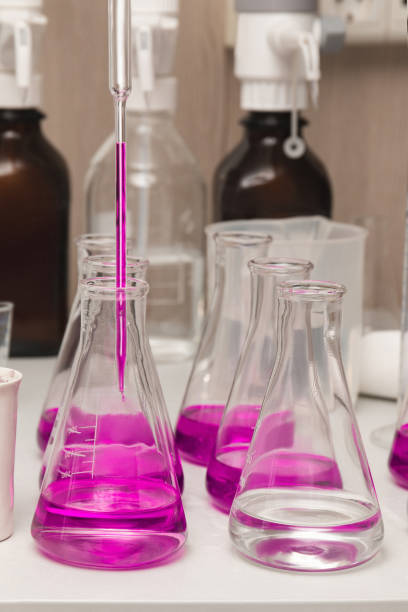 flasks with liquid colored pink. chemical analysis, organic test of water in the laboratory - casting glass photos et images de collection