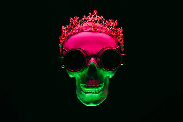 human skull in a crown and steampunk glasses with colored pink green neon light