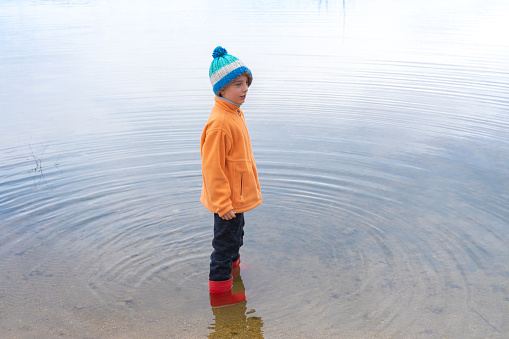 Boy with wellies in a lake