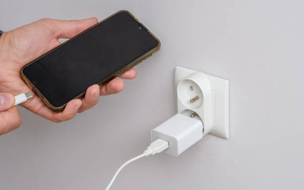 connectez un smartphone dont la batterie est déchargée et vide à l’alimentation électrique - white meat photos et images de collection