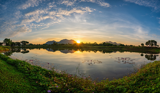 Tropical forest nature landscape with mountain range and pond water sunrise at Mae Moh mine, Lampang Thailand panorama