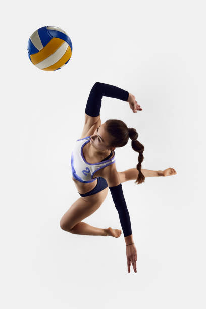 istock Top view. Dynamic image of athletic female volleyball player in motion, practicing, jumping with ball isolated over white studio background. 1937077667