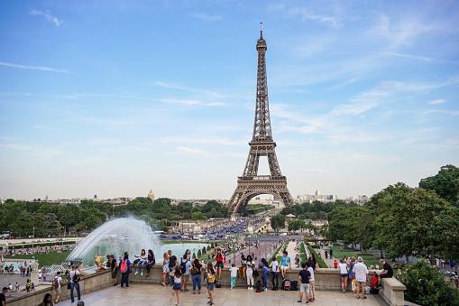 Paris, France - July 18, 2017: Lot of people enjoying day and relaxing on Trocadero square and garden with Eiffel Tower in background. Sunny evening just before sunset.