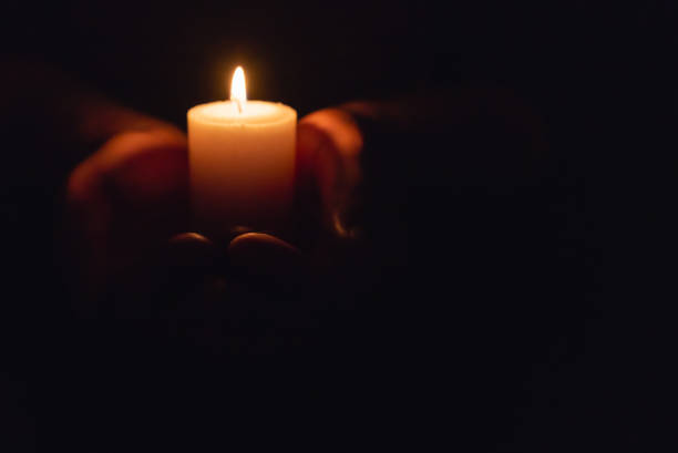 istock Hands holding burning candle in dark like a heart.Selective focus,black background.Copy space. 1937092112