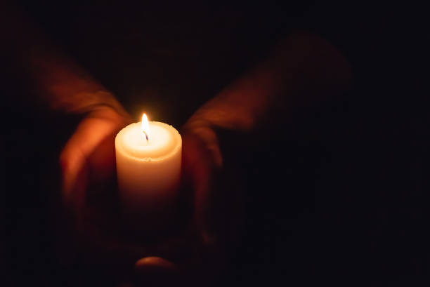 istock Hands holding burning candle in dark like a heart.Selective focus,black background.Copy space. 1937092122