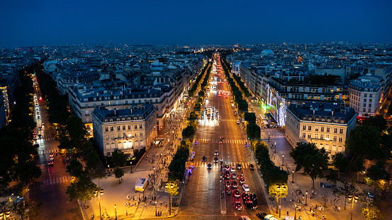 Aerial view of Avenue des Champs-Elysees, one of the well known parts of city of Paris at night. Illuminated buildings, traffic, city life