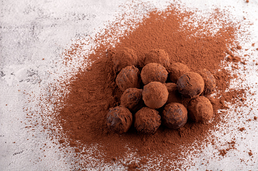 Horizontal photography featuring homemade chocolate truffles. These delights, coated in cocoa powder, present a sweet and tempting treat. heap, isolated, sweet food, energy, dark chocolate