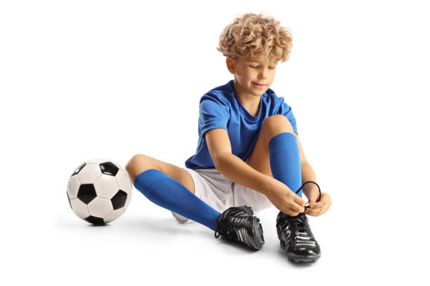 istock Boy in a football kit putting on cleats 1937111992
