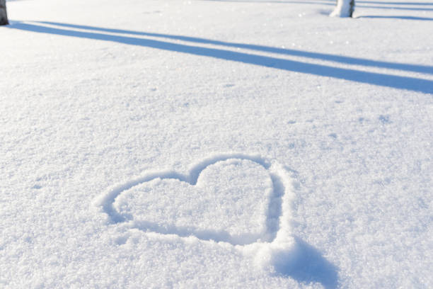 istock One hand drawn heart shape in the fresh snow.Top view,closeup,copy space. 1937113012