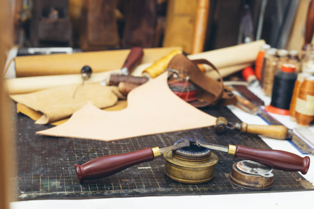 istock Tools and leather at cobbler workplace. Set of leather craft tools on background. 1937121188