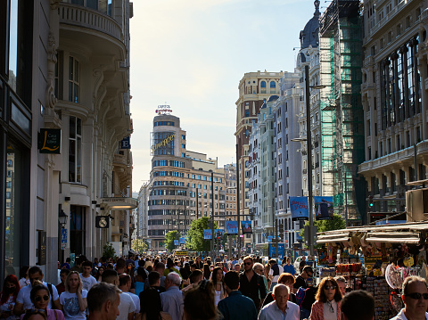 Madrid, Spain - May 06, 2022\nThrong or crowd of people on the Gran Via in the Spanish Capital city. Rush hour in Madrid with a big crowd running in the city downtown. Latin vibes on busy streets