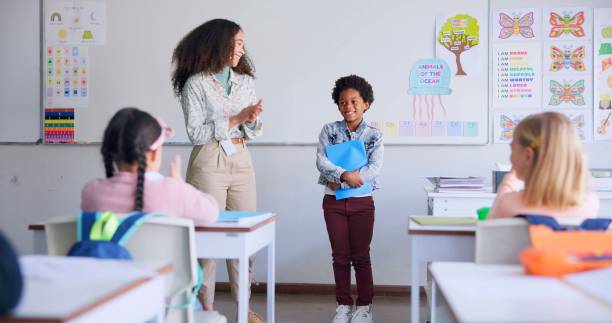istock Class paper, presentation and child speaker with applause and cheering in classroom at school. Young kid, education and oral reading of project with student and teacher with children group discussion 1937157450
