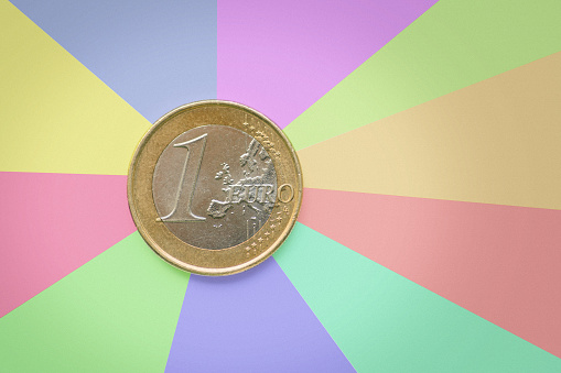A 1 euro coin over a colorful background