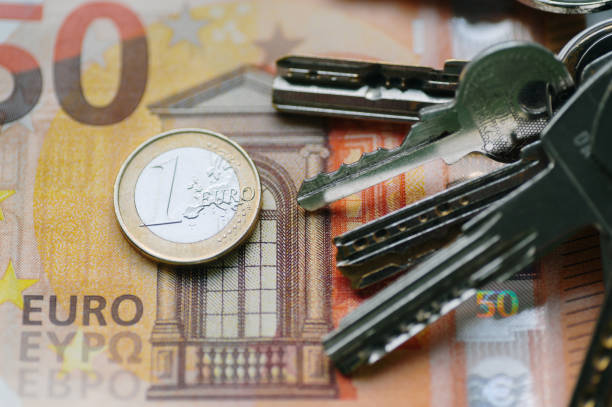 Euro coin and bill next to house keys