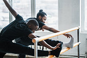 Black men stretching and warming up in dance studio before training