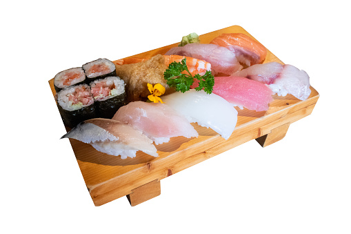 Set of various kinds and types of Japanese food sushi fish ready to eat on a wooden tray on a white background.