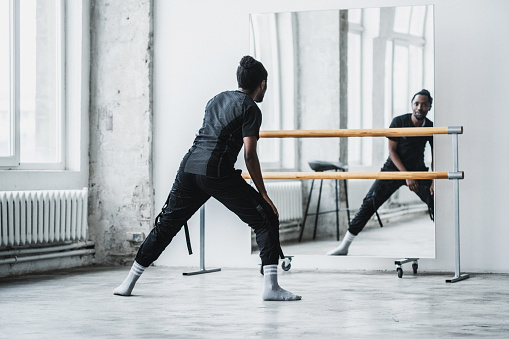 Black man warming up in dance studio