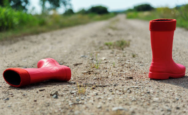 Red rubber boots on the gravel road.