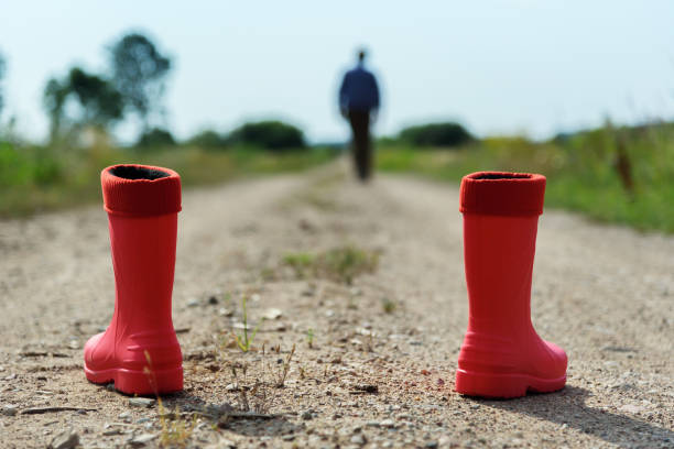 Red rubber boots on the gravel road.
