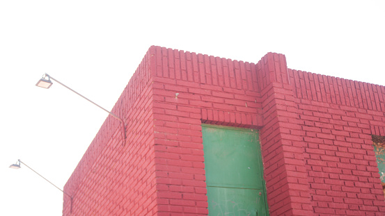 Green door in red brick shed