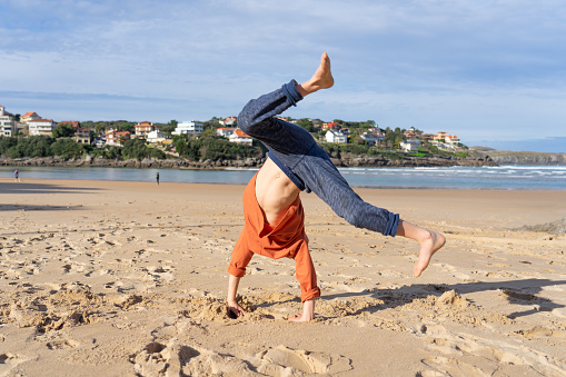Boy doing cartwheel on the beach