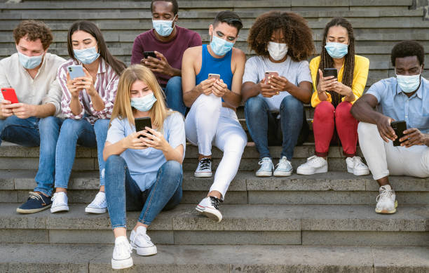 istock Young multiracial group of friends using mobile smartphone while wearing face mask during covid19 - Youth millennial lifestyle concept 1937191616