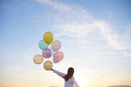 Japanese woman with sunset sky and colorful balloons