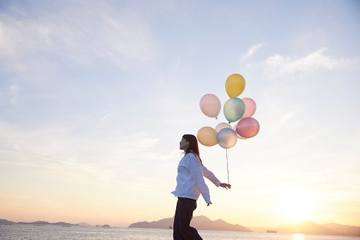 Japanese woman with sunset sky and colorful balloons