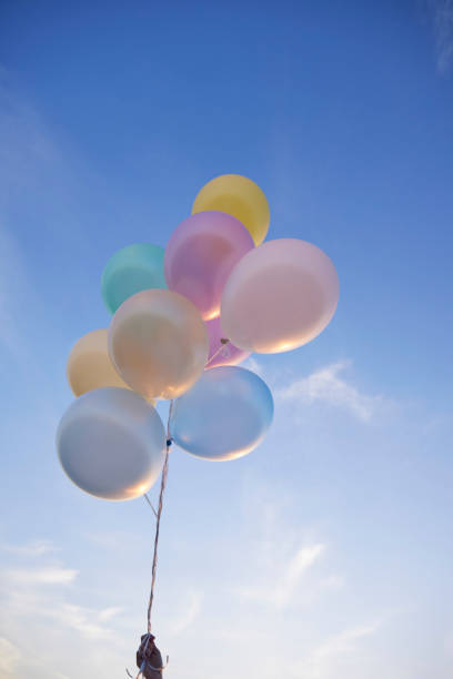 A gas-filled balloon floats in the shape of a smiling face.