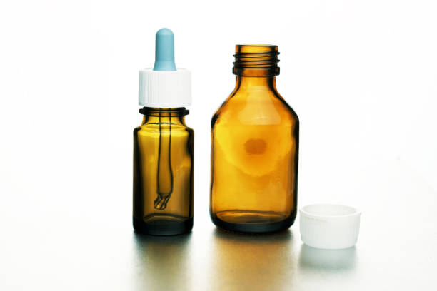 Medical vial with a cap and a pipette, on a white background,