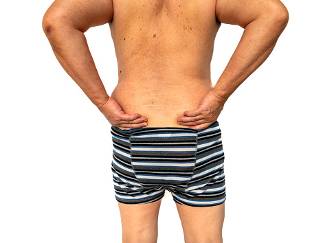 A full back view of a person suffering from back pain isolated in white.