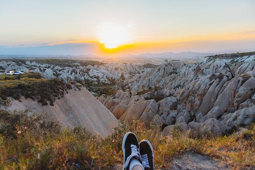 Personal perspective footage of female's legs admiring the sunset with a view of the beautiful valley Göreme National park, Middle East