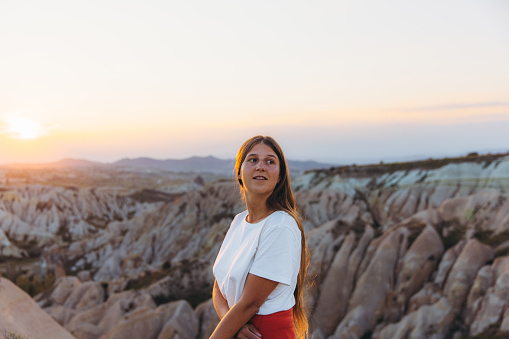 Portrait of a happy female with long hair admiring the sunset with a view of the beautiful valley Göreme National park, Middle East