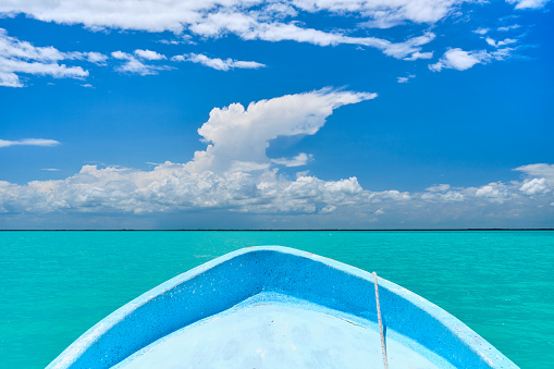 A small boat in the turquoise waters of the Caribbean Sea, in the Sian Ka'an biosphere reserve, in the Mexican state of Quintana Roo (Riviera Maya).