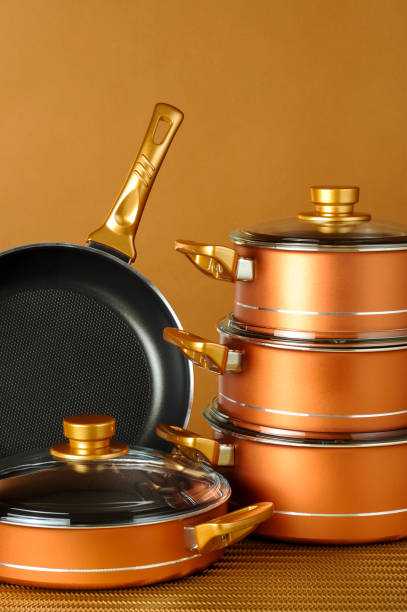 Set of black non-stick kitchen utensils on a orange background