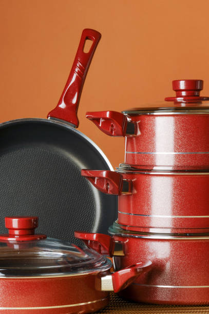 Set of black non-stick kitchen utensils on a orange background