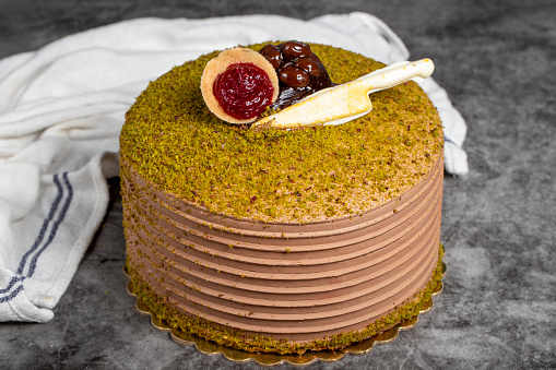 Pistachio birthday cake. Strawberry and pistachio cake on dark background. Close up