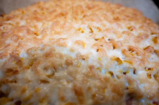 Close-up of a baked pizza with chees.