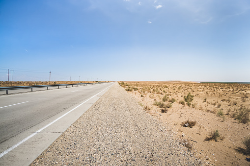 Automobile asphalt highway highway in the hot Kyzylkum desert of Uzbekistan