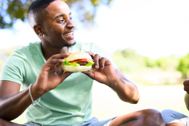 istock Young man holding healthy burger with salad and tomato 1937331621