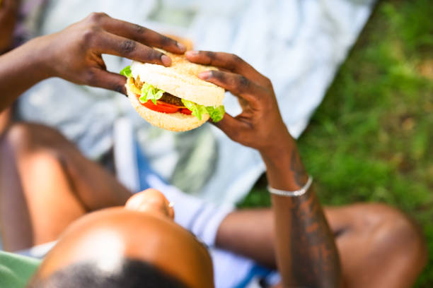 istock Over shoulder close up view young man holding vegan burger 1937332149