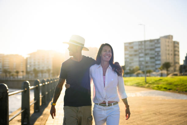 An adult woman walks with young boy down the street towards the sun
