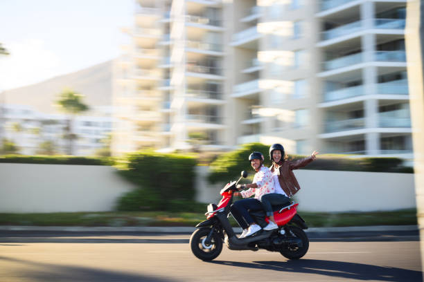 istock Panning shot with motion blur couple having fun riding scooter 1937339716