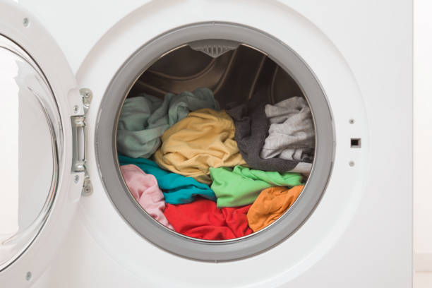 istock White opened washing machine full of colorful clothes. Closeup. Front view. 1937354448