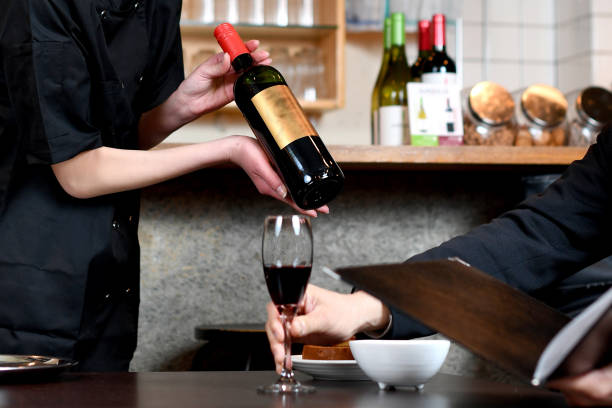 istock Asian female clerk explaining wine to a man at a restaurant 1937392963