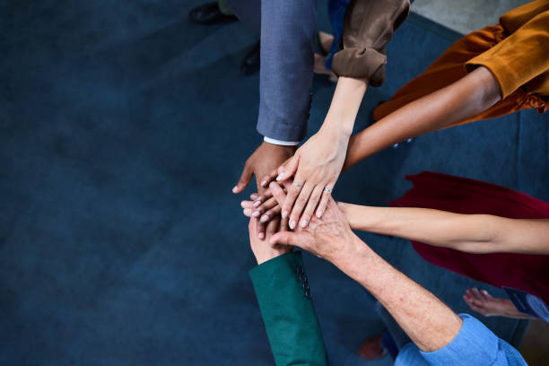 istock Diverse businesspeople standing in an office with their hands stacked together 1937394067