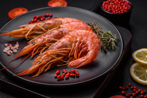 Tiger shrimp or langoustine boiled with spices and salt on a dark concrete background