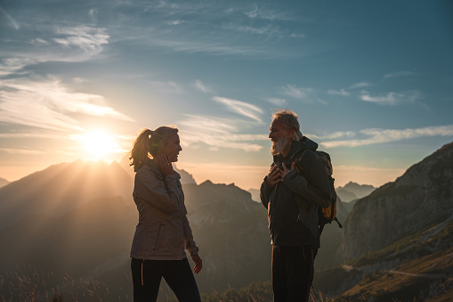 A romantic journey unfolds in the mountains as a mature Caucasian couple shares a special moment, with the man orchestrating a surprise engagement proposal.