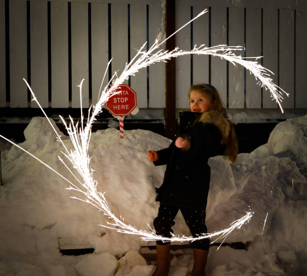 A young child gleefully enjoys the winter wonderland, frolicking in the snow by a red stop sign